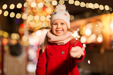 Image showing happy girl with sparkler at christmas market