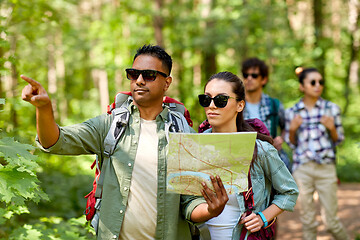 Image showing friends with map and backpacks hiking in forest