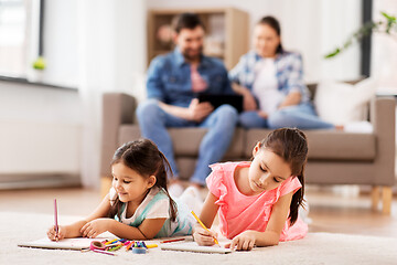 Image showing happy sisters drawing in sketchbooks at home