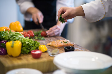 Image showing Chef hands preparing marinated Salmon fish