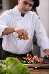 Image showing Chef finishing steak meat plate