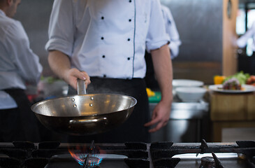 Image showing chef flipping vegetables in wok