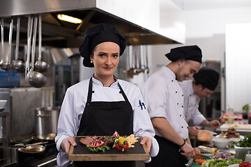 Image showing female Chef holding beef steak plate