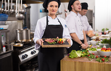 Image showing female Chef holding beef steak plate