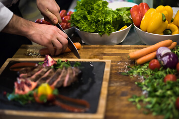 Image showing closeup of Chef hands serving beef steak