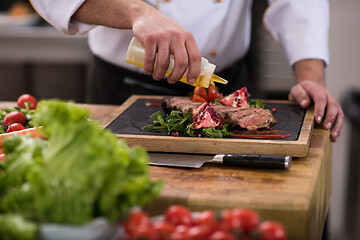 Image showing Chef finishing steak meat plate