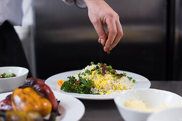 Image showing Chef hands serving vegetable risotto