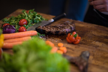 Image showing closeup of Chef hands preparing beef steak