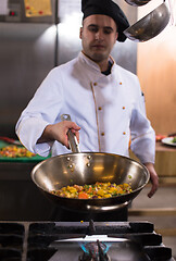 Image showing chef flipping vegetables in wok