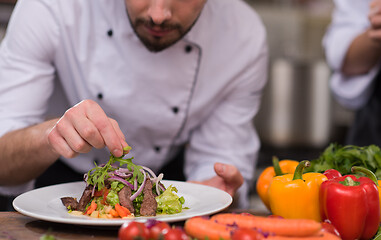 Image showing cook chef decorating garnishing prepared meal