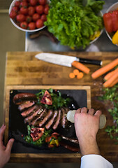 Image showing top view of Chef finishing steak meat plate