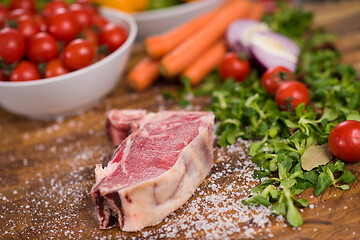 Image showing Juicy slice of raw steak on wooden table