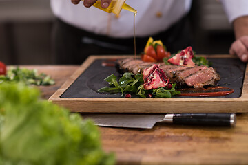 Image showing Chef finishing steak meat plate