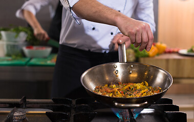 Image showing chef putting spices on vegetables in wok