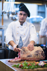 Image showing chef cutting big piece of beef