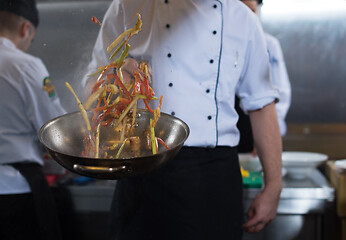 Image showing chef flipping vegetables in wok