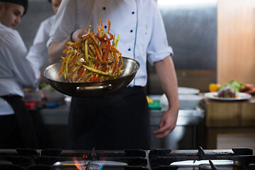 Image showing chef flipping vegetables in wok