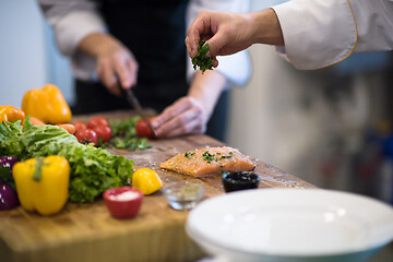 Image showing Chef hands preparing marinated Salmon fish