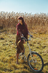 Image showing Pretty girl riding bicycle in field