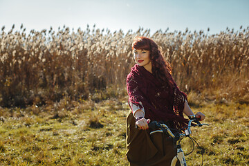 Image showing Pretty girl riding bicycle in field