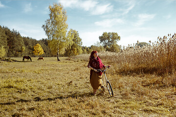 Image showing Pretty girl riding bicycle in field