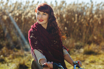 Image showing Pretty girl riding bicycle in field