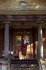 Image showing Girl standing on old house balcony