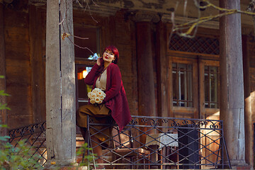 Image showing Girl sitting on old house balcony