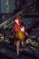 Image showing Girl sitting on old house stairs