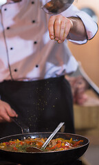 Image showing chef putting spices on vegetables in wok