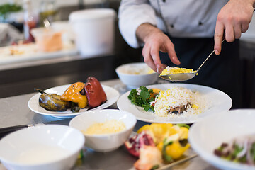 Image showing Chef hands serving vegetable risotto