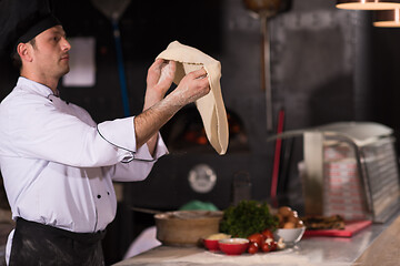 Image showing chef throwing up pizza dough