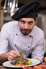 Image showing cook chef decorating garnishing prepared meal