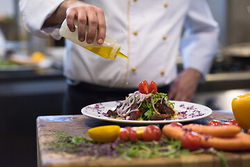 Image showing Chef finishing steak meat plate