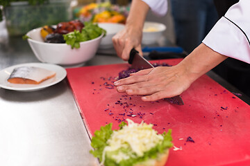 Image showing chef hands cutting salad for burger