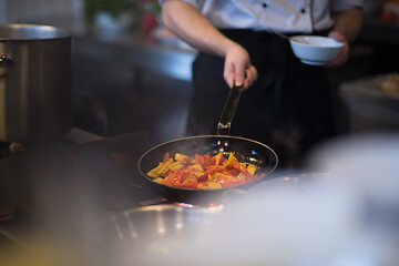 Image showing chef flipping vegetables in wok