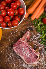 Image showing top view of raw steak on wooden table