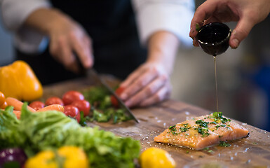 Image showing Chef hands preparing marinated Salmon fish