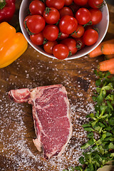 Image showing top view of raw steak on wooden table