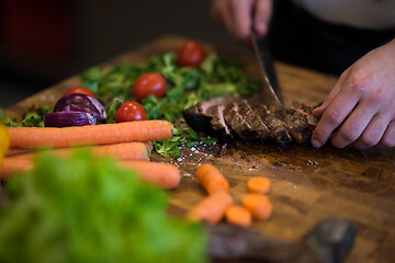 Image showing closeup of Chef hands preparing beef steak