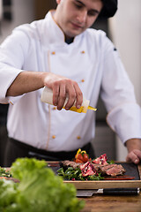 Image showing Chef finishing steak meat plate