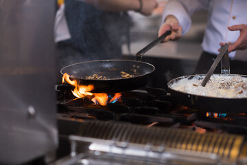 Image showing chef preparing food, frying in wok pan