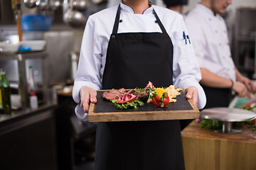 Image showing female Chef holding beef steak plate