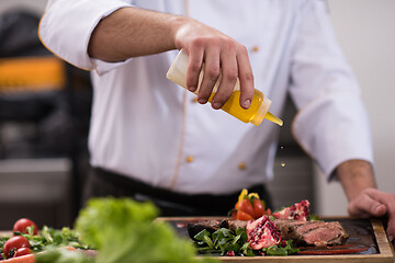 Image showing Chef finishing steak meat plate