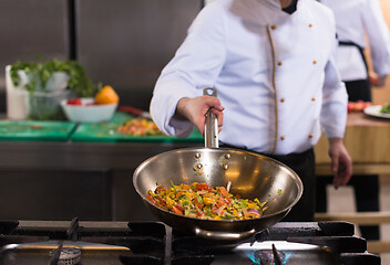 Image showing chef flipping vegetables in wok