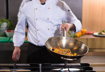 Image showing chef flipping vegetables in wok