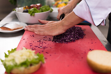 Image showing chef hands cutting salad for burger