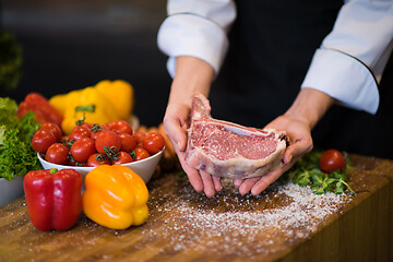 Image showing Chef holding juicy slice of raw steak