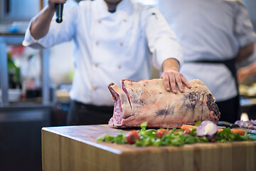 Image showing chef cutting big piece of beef