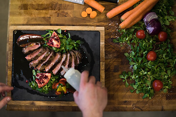 Image showing top view of Chef finishing steak meat plate